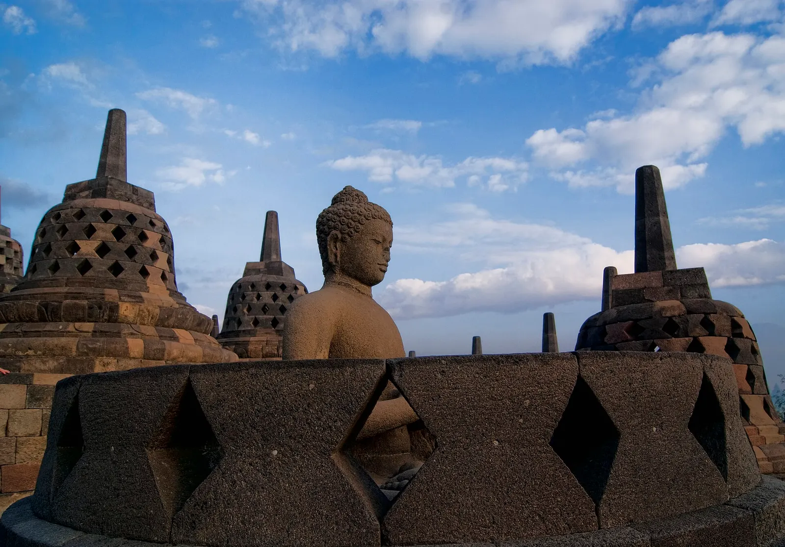 Stupas and a seated Buddha on the upper terrace of Borobudur
