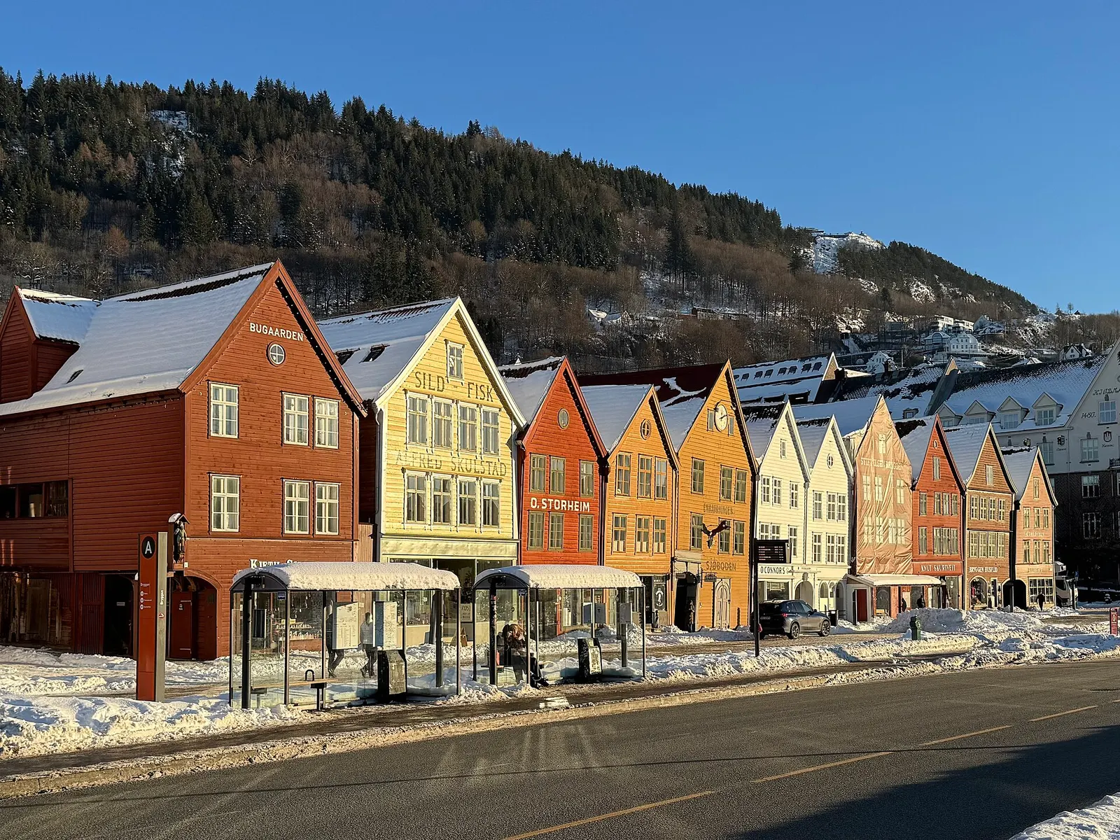 Wooden wharf houses of Bryggen in Bergen under winter snow