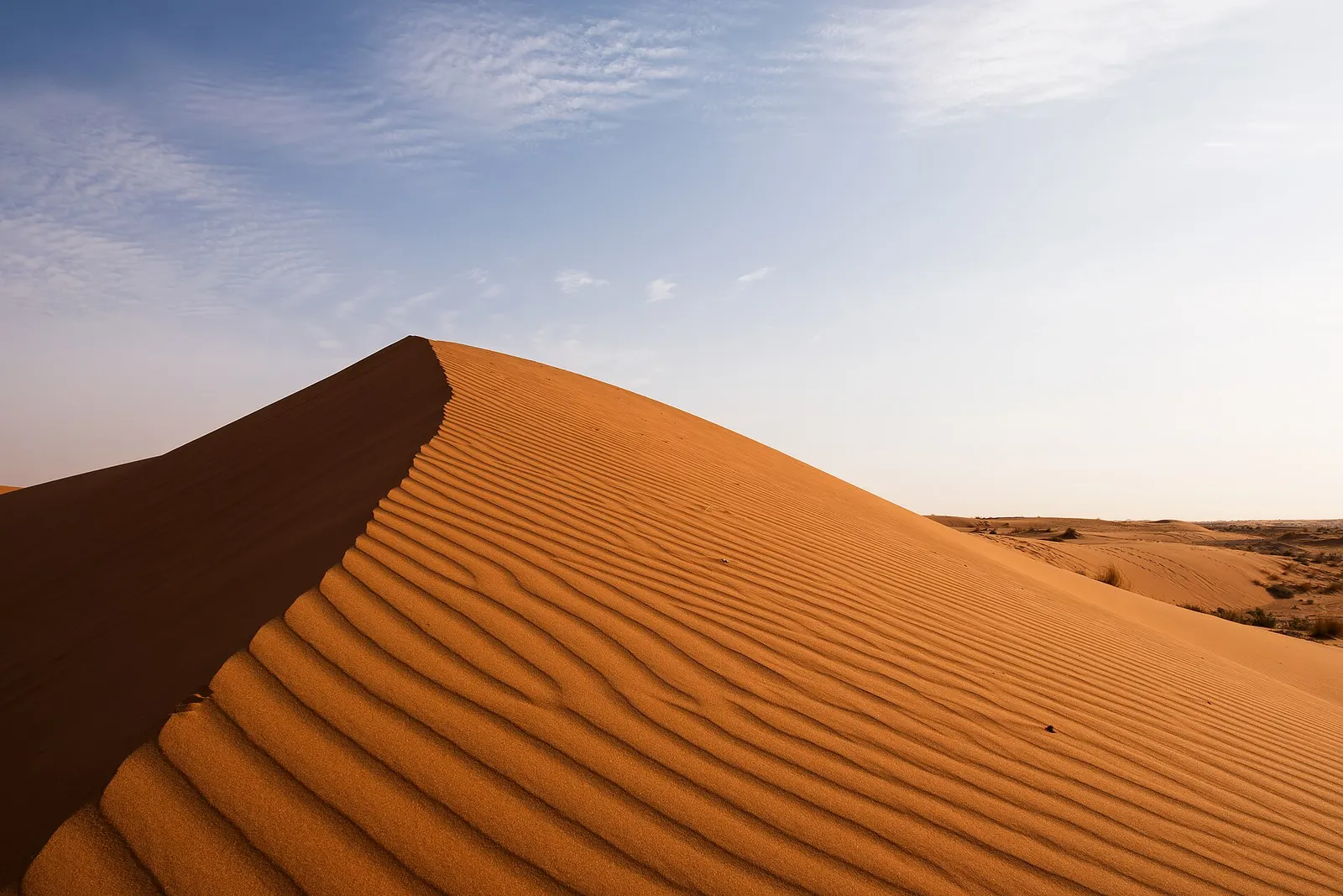 Rippled red sand dune under a clear sky in Saudi Arabia