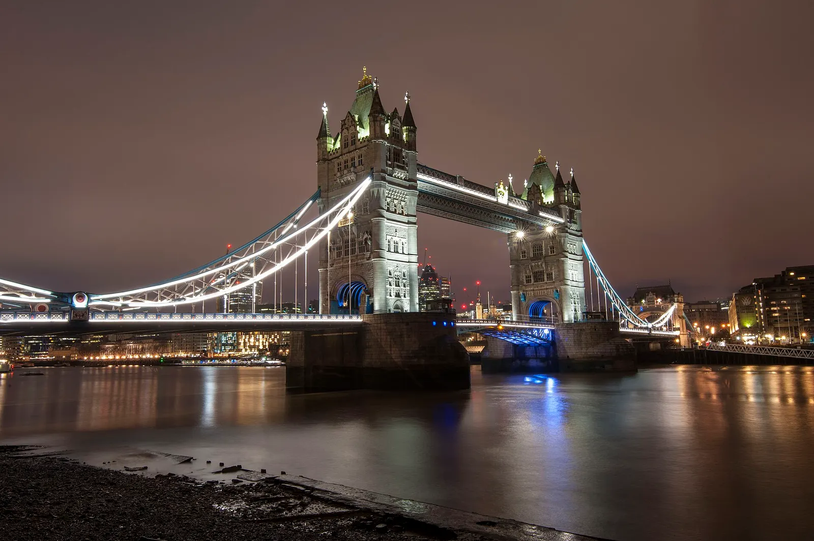 Tower Bridge in London lit up at night over the Thames
