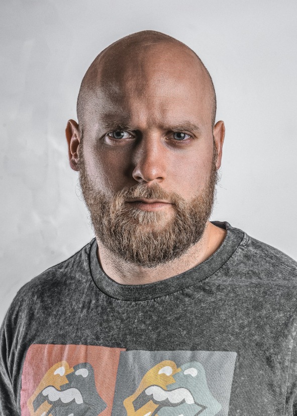 Canadian passport file our tool made, 50 x 70 mm: bald, bearded man in a grey crew-neck top on his own light grey wall, unaltered