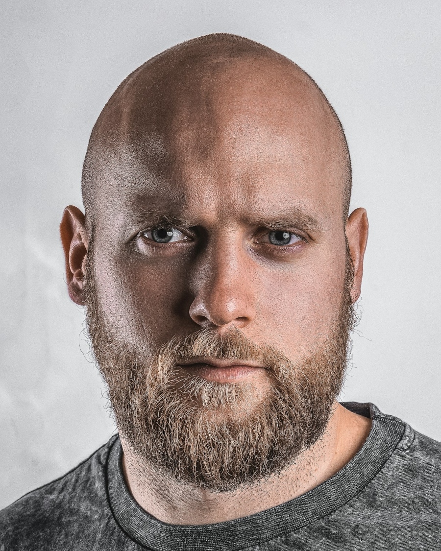 UK digital passport file our tool made: bald, bearded man in a grey crew-neck top on his own light grey wall