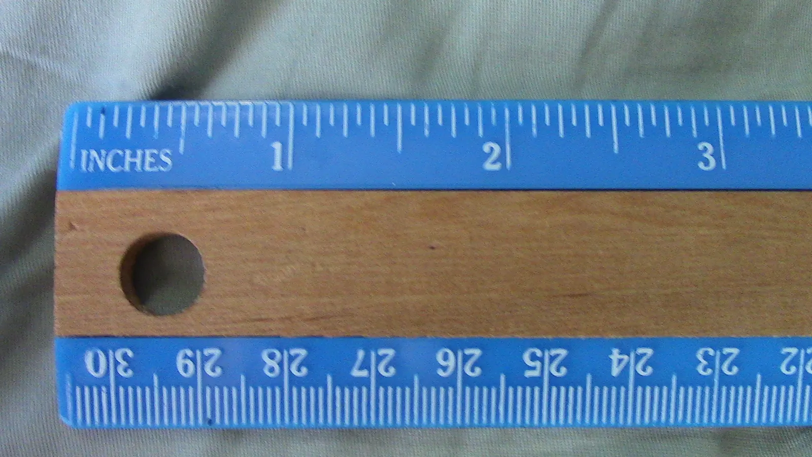Wooden ruler showing inches on one edge and centimetres on the other
