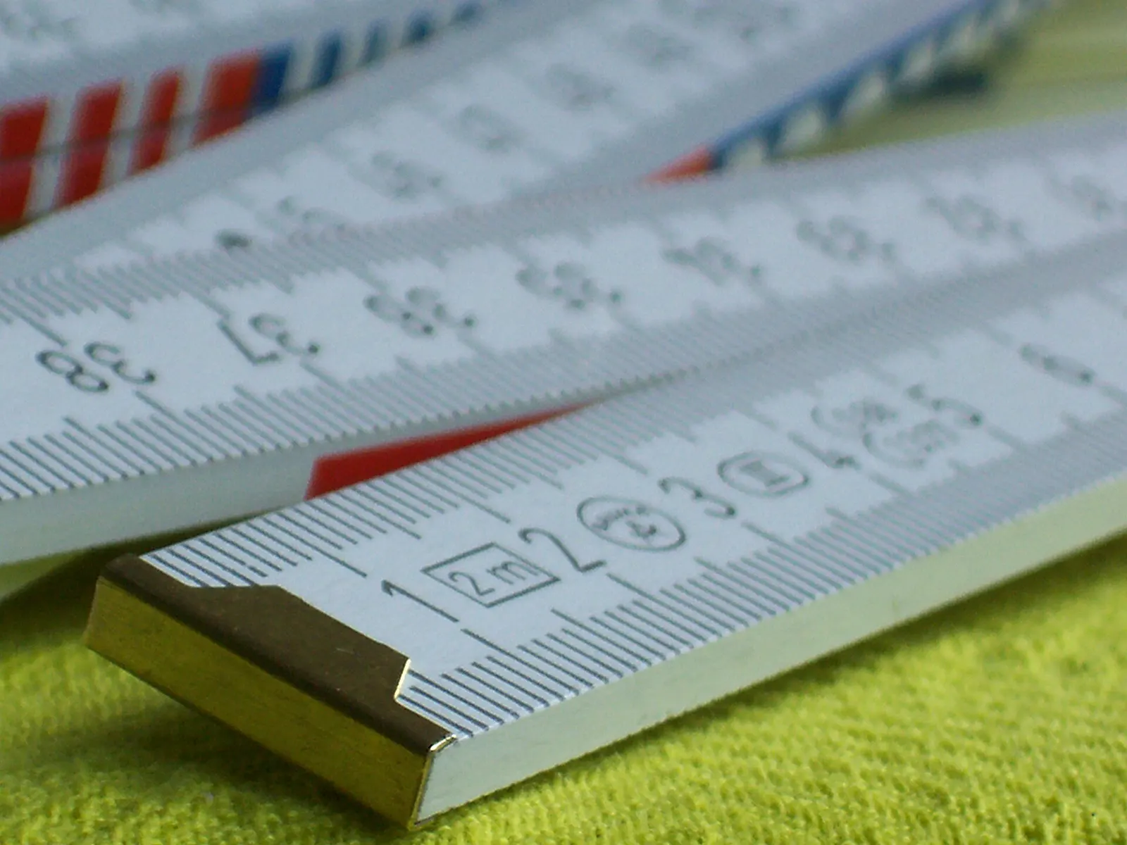 Wooden folding rules marked in centimetres on a yellow cloth