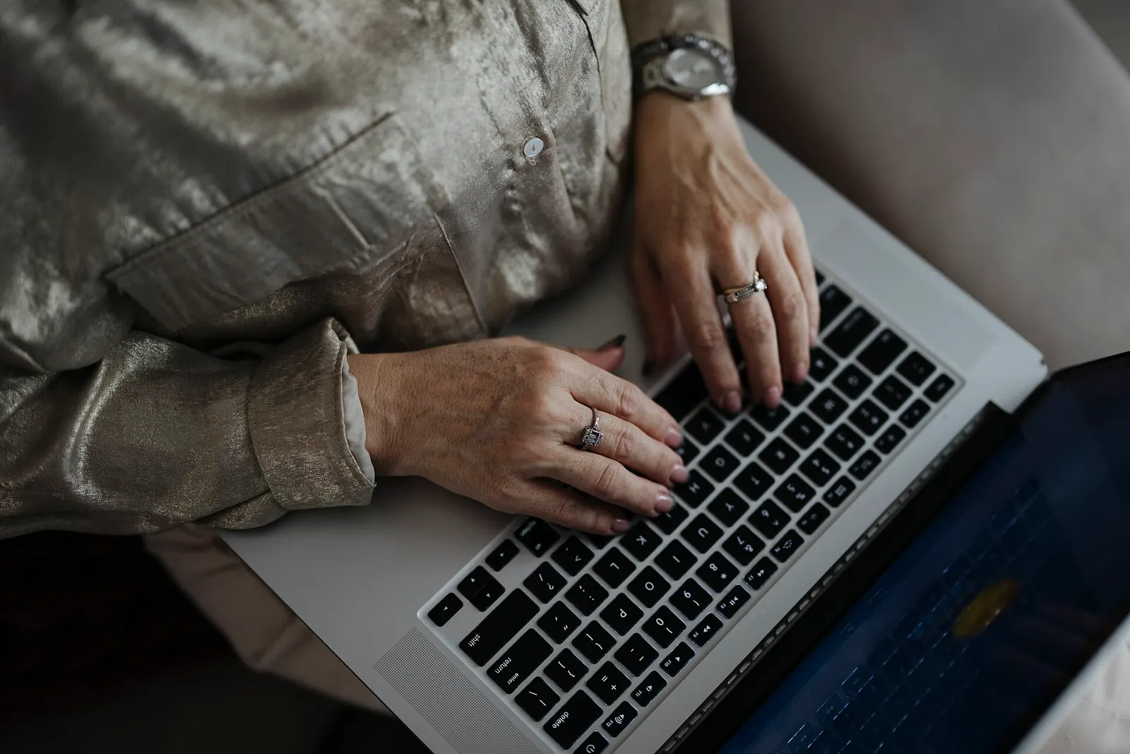 Hands typing on a laptop at a home desk in daylight