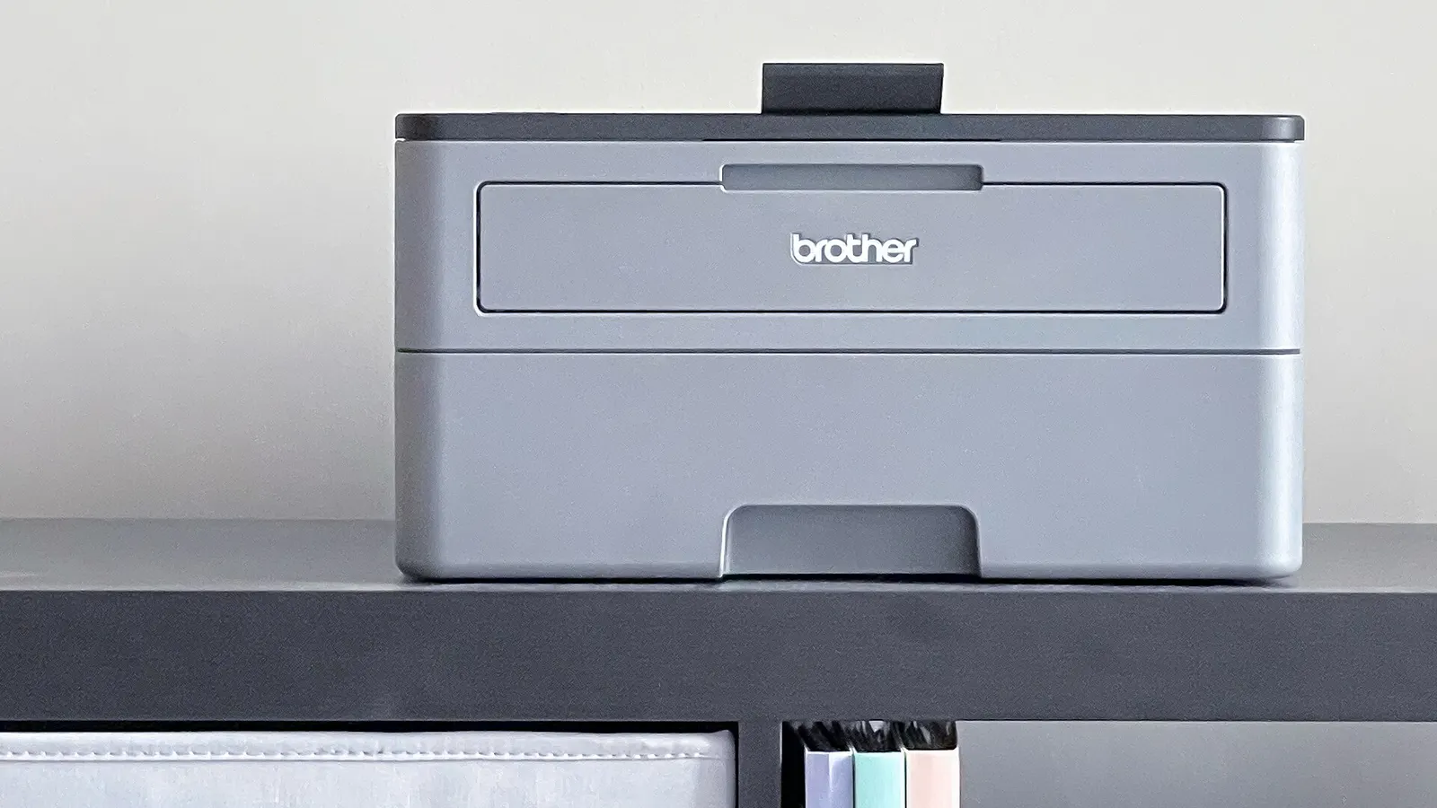 Compact desktop printer on a shelf above a desk